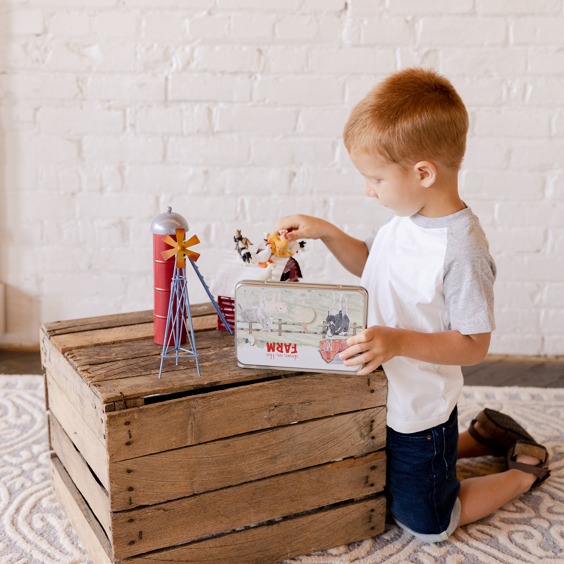 Child Playing with Large Magnetic Animal Tin Farm Set